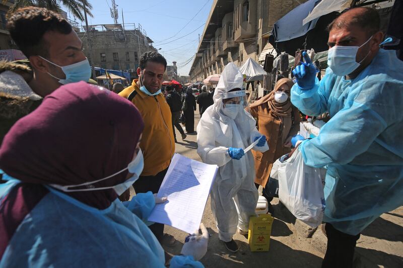 Iraqi health workers collect swab samples for Covid-19 testing at the Shorja market in Baghdad.