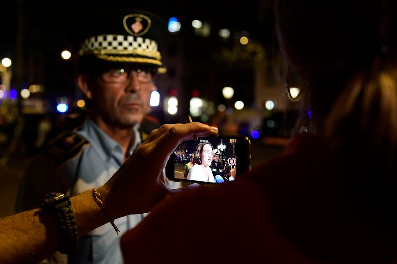 A journalist films with his smartphone as Barcelona's Mayor Ada Colau speaks to the press on the Rambla boulevard after a van ploughed into the crowd, killing at least 13 people and injuring around 100 others on the Rambla in Barcelona on August 17, 2017.
A driver deliberately rammed a van into a crowd on Barcelona's most popular street on August 17, 2017 killing at least 13 people before fleeing to a nearby bar, police said. 
Officers in Spain's second-largest city said the ramming on Las Ramblas was a "terrorist attack". The driver of a van that mowed into a packed street in Barcelona is still on the run, Spanish police said. / AFP PHOTO / JAVIER SORIANO