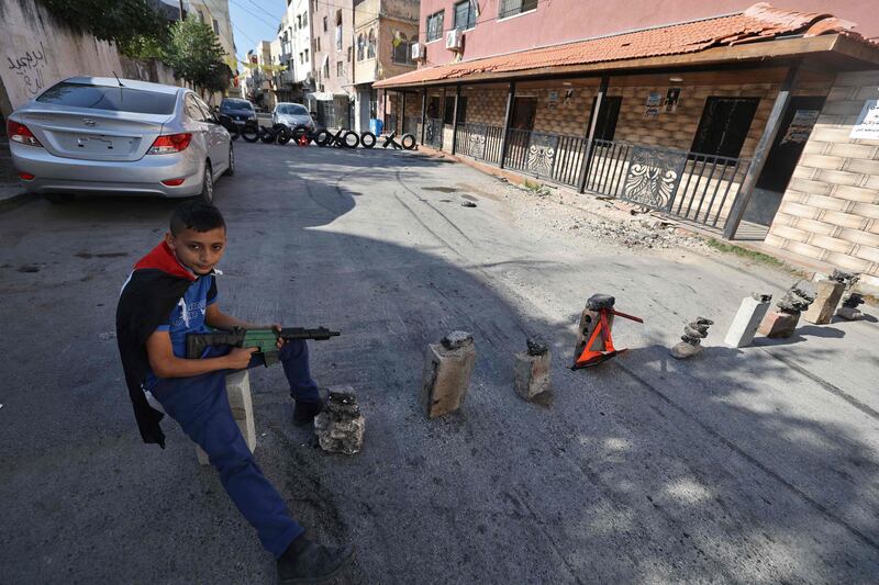 A Palestinian boy with a toy gun in Jenin, in the occupied West Bank, where real guns are causing strife. AFP