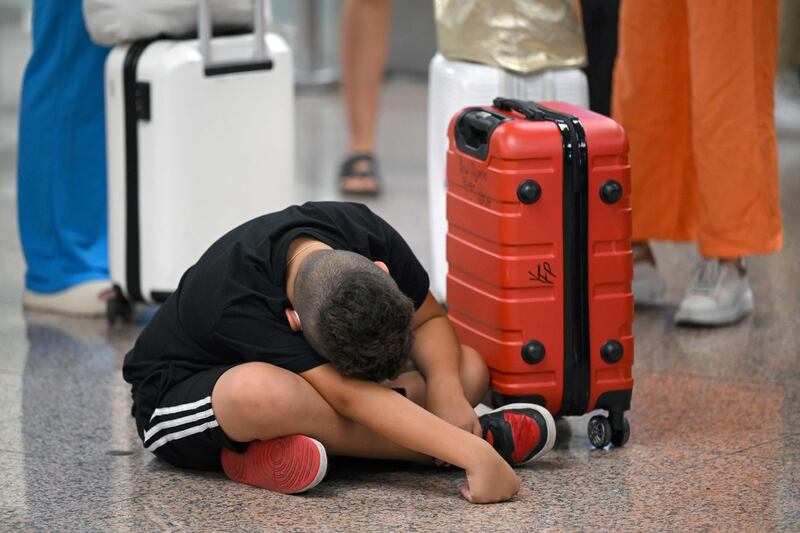 A young passengers tries to sleep at El Prat airport in Barcelona. AFP