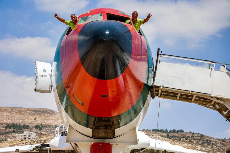 Palestinian twin brothers Atallah and Khamis Al Sairafi, 60, wave from the cockpit of a Boeing 707 being converted into a restaurant in Nablus in the occupied West Bank.