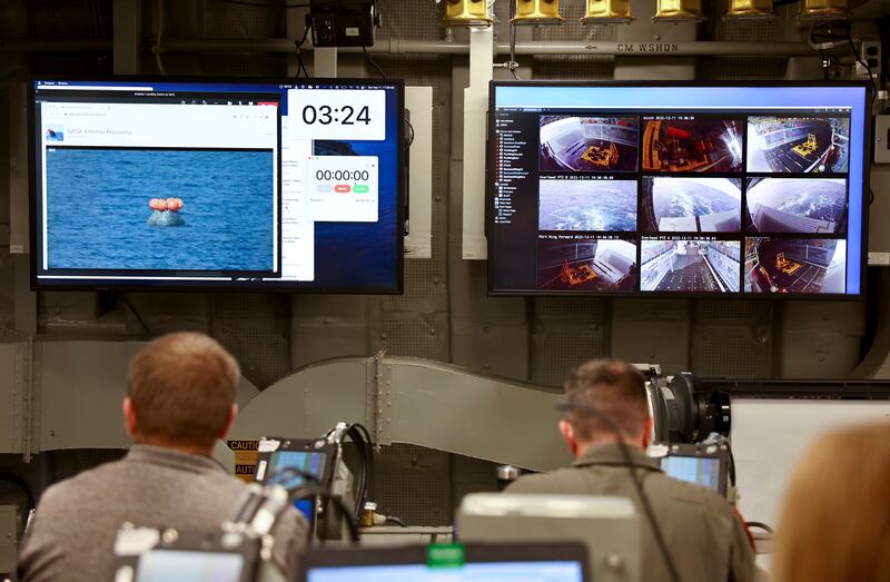 Officers in the USS Portland's command centre monitor the recovery operation. AP