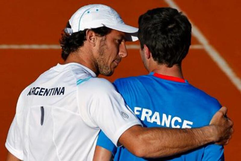 Argentina's Juan Monaco (L) consoles France's Gilles Simon after Simon was defeated by Argentina's Carlos Berlocq in their Davis Cup singles quarter-final tennis match in Buenos Aires April 7, 2013. REUTERS/Marcos Brindicci (ARGENTINA - Tags: SPORT TENNIS)
