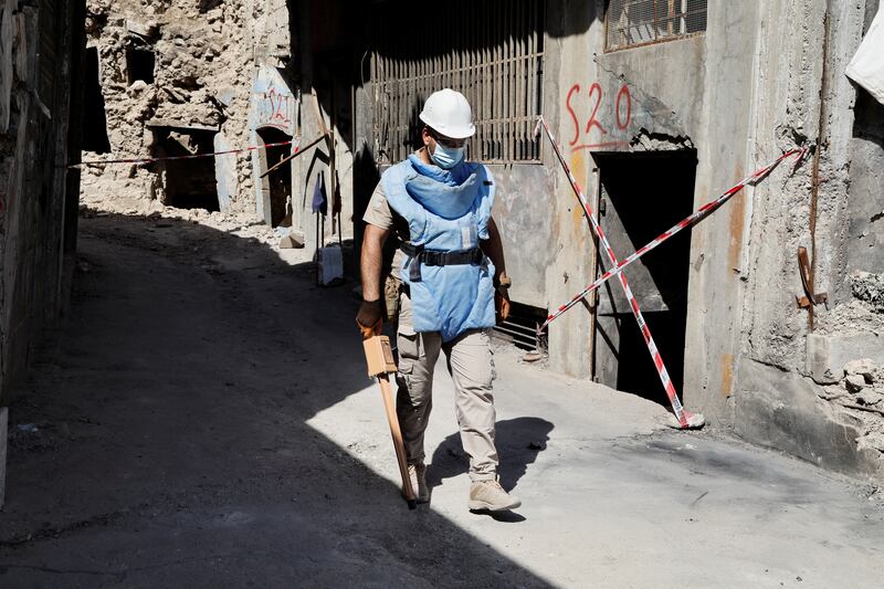 A member of a demining squad walks down a street during an operation to clear mines planted by ISIS militants in the Old City of Mosul.