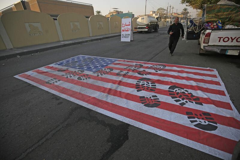 A mock US flag is laid on the ground for cars to drive on in the Iraqi capital Baghdad. AFP