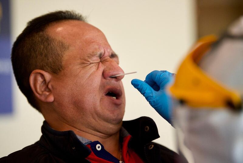 A passenger is tested for COVID-19 by Health Ministry personnel at Quito's International Airport as Ecuador resumes domestic flights amid the novel coronavirus pandemic.  AFP