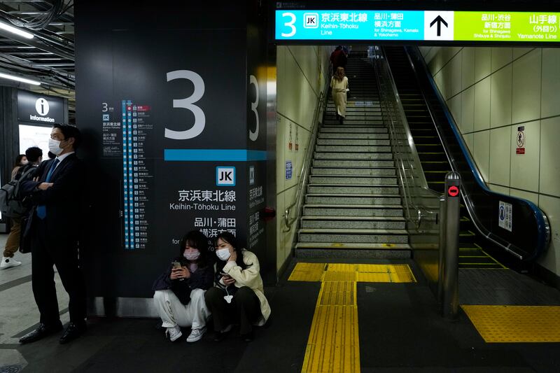 Travellers wait for rail services to resume at a train station in Tokyo. AP