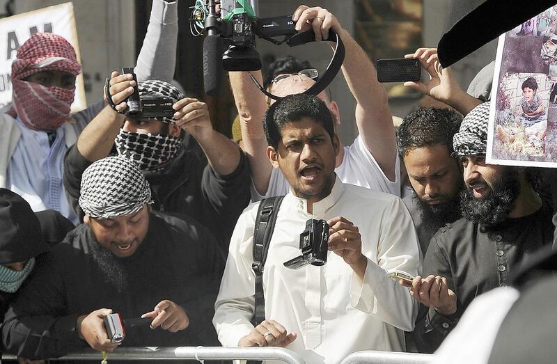 A file picture shows a man identified by local media as Siddharta Dhar, centre in white, as he takes part in a demonstration outside the US embassy in central London, September 11, 2011. Dhar is widely identified by local media as the masked figure with a British accent in the latest video distributed by ISIL which shows the execution of 5 men. Paul Hackett/Reuters