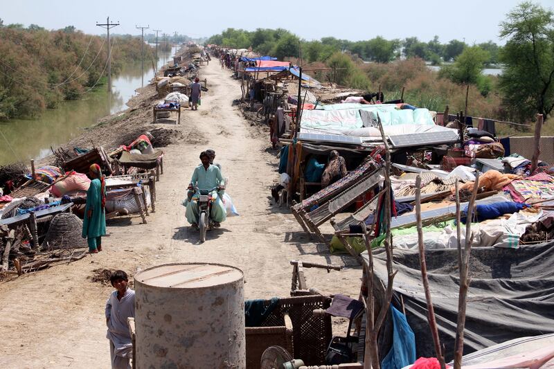 Displaced people take shelter on an elevated motorway to escape rising floodwaters. EPA