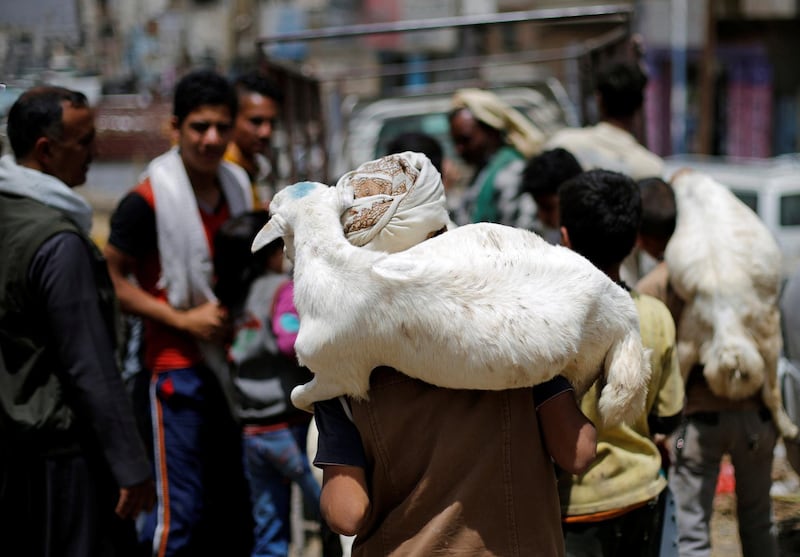 A boy carries a goat at a livestock market where people buy sacrificial animals ahead of the Eid al-Adha celebrations in Sanaa, Yemen. REUTERS