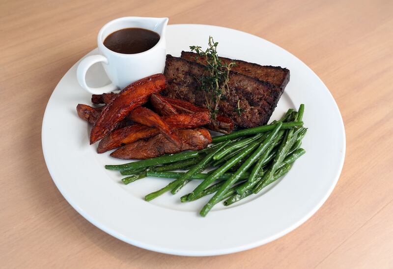 The meatloaf is made with Impossible meat, slathered with onion gravy and comes with a side of sweet potato fries and green beans