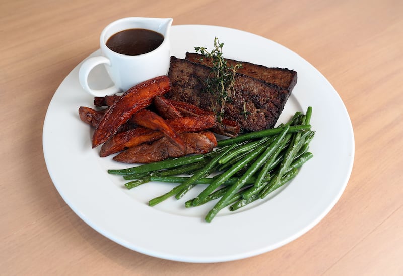 The meatloaf is made with Impossible meat, slathered with onion gravy and comes with a side of sweet potato fries and green beans