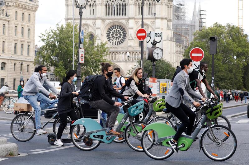 Bikers wearing protective masks ride past Notre Dame Cathedral, as France reinforces mask-wearing as part of efforts to curb a resurgence of Covid-19 across the country, in Paris, France August 28, 2020. Reuters