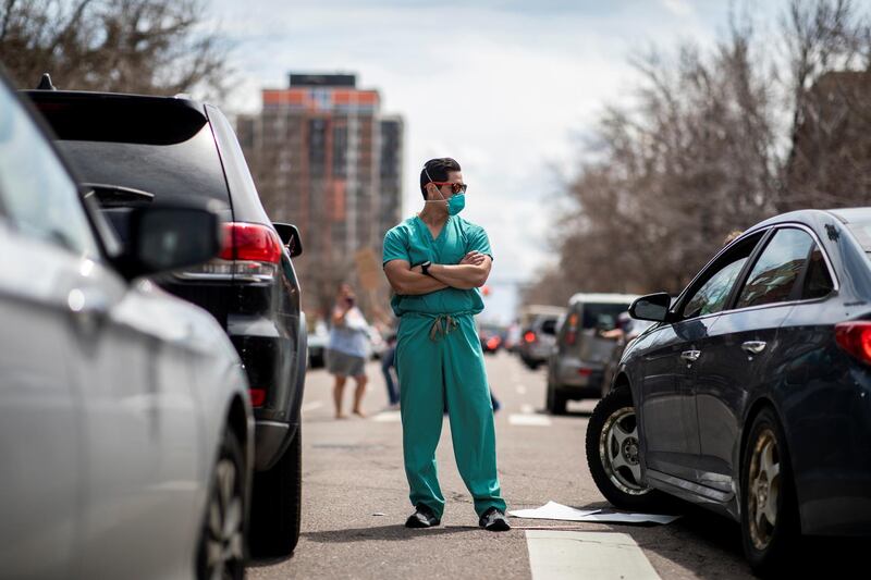 Healthcare workers stand in the street in counter-protest to hundreds of people who gathered at the State Capitol to demand the stay-at-home order be lifted in Denver, Colorado, US. Reuters