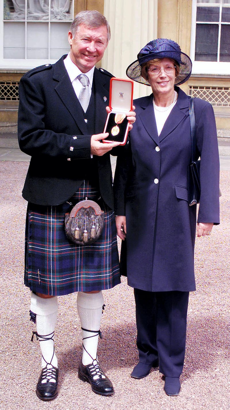 Manchester United manager Sir Alex Ferguson and wife Cathy pose for photographs July 20, 1999. Ferguson was knighted by Britain's Queen Elizabeth II during an investiture ceremony at Buckingham Palace.

REUTERS/Pool

PS/GB - RP1DRILVDWAB