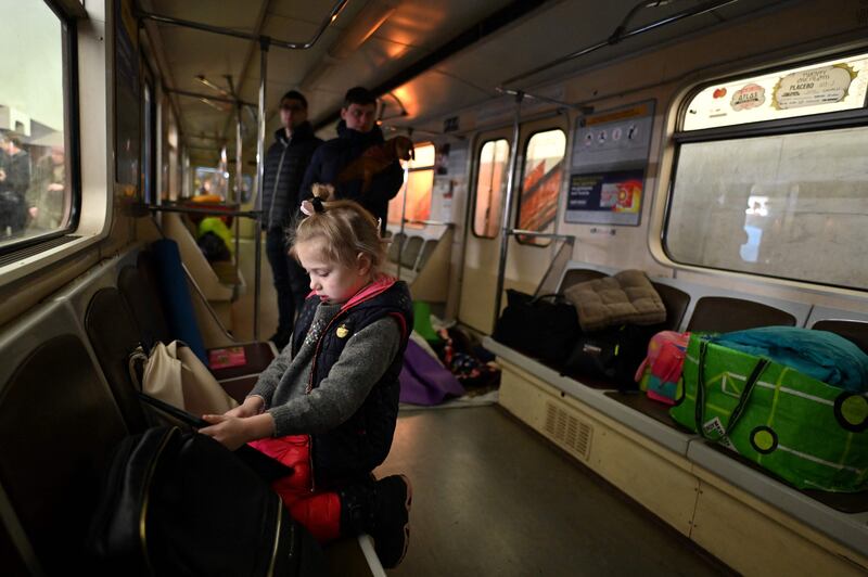 A girl plays games on her tablet inside a subway carriage being used as a bomb shelter in Kyiv. AFP