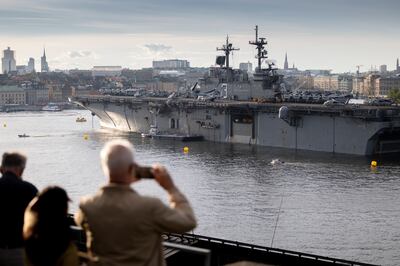People on the dockside in Stockholm, Sweden look at an American warship arriving for Nato exercises. Getty 