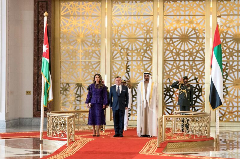 ABU DHABI, UNITED ARAB EMIRATES - February 07, 2018: HH Sheikh Mohamed bin Zayed Al Nahyan Crown Prince of Abu Dhabi Deputy Supreme Commander of the UAE Armed Forces (R) and HM King Abdullah II, King of Jordan (C), stand for the national anthem during a reception at the Presidential Airport. Seen with HM Queen Rania Al Abdullah Queen of Jordan (L).

( Hamad Al Kaabi / Crown Prince Court - Abu Dhabi )
—