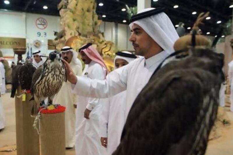 Visitors to last year's Adihex examine falcons on sale. This year's event, which takes place at Abu Dhabi National Exhibition Centre next week, promises to be a showcase for Emirati traditions. Ravindranath K / The National