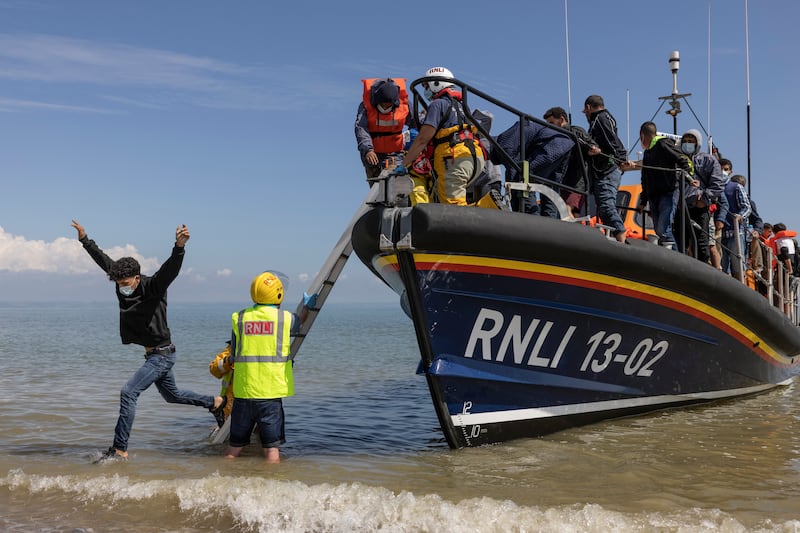 A group of about 40 people arrive by lifeboat on a British beach after a lull caused by bad weather. Getty Images