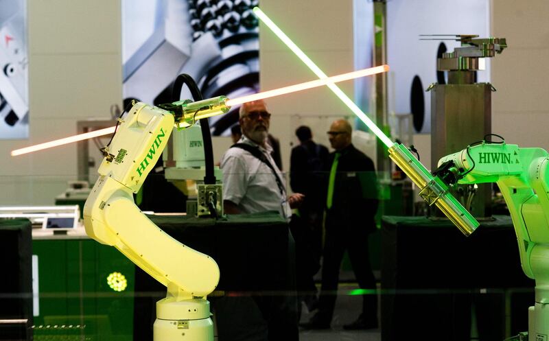 Robots from the company HIWIN from Taiwan swivel lightsabers during the Hannover Fair on April 23, 2018 in Hanover, Germany.
The Hanover technology fair runs until April 28, 2018, with Mexico as partner country. / AFP PHOTO / dpa / Julian Stratenschulte / Germany OUT