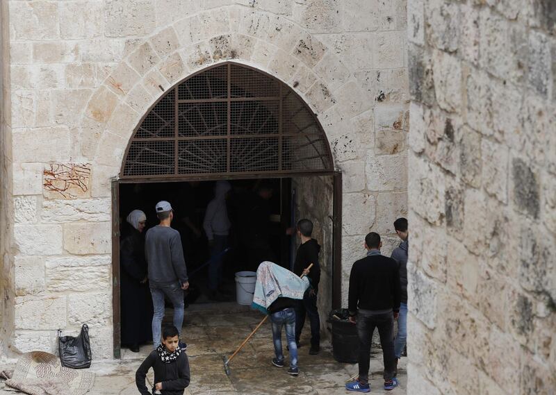 Palestinian protesters gather around an entrance to the Golden Gate or Gate of Mercy inside the Al-Aqsa mosques compound in Jerusalem's Old City on March 15, 2019 after they broke its wooden door following the Friday prayers, in protest against a ban imposed by Israel on entering the disputed site. 
 Muslim worshippers have been entering the site despite an Israeli order that it should stay closed. The Golden Gate is inside the Al-Aqsa mosques compound, the third-holiest shrine in Islam and a focus of Palestinian aspirations for statehood, but it is also the location of Judaism's most holy spot, revered as the site of the two biblical-era Jewish temples. Access to the Golden Gate was closed in 2003 during the second Palestinian intifada over alleged militant activity there, according to Israeli police.
Jews are allowed to visit but cannot pray there and it is a frequent scene of conflict between the two sides. / AFP / AHMAD GHARABLI
