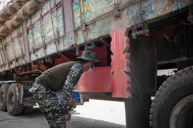 A border guard from Pakistan searches for children hiding in the belly of a lorry that has just crossed from Afghanistan into Pakistan.