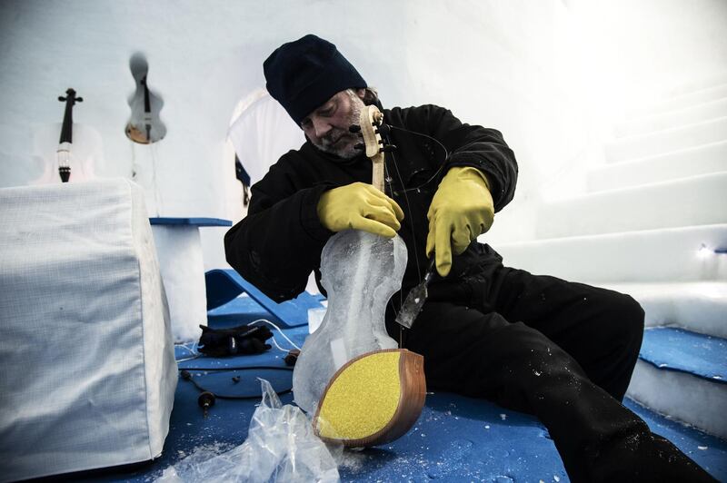 Tim Linhart carves an ice violin. AFP