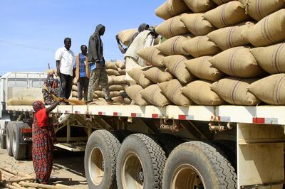 Sudanese workers sort sacks of grains on a lorry at a market in Gedaref. AFP 