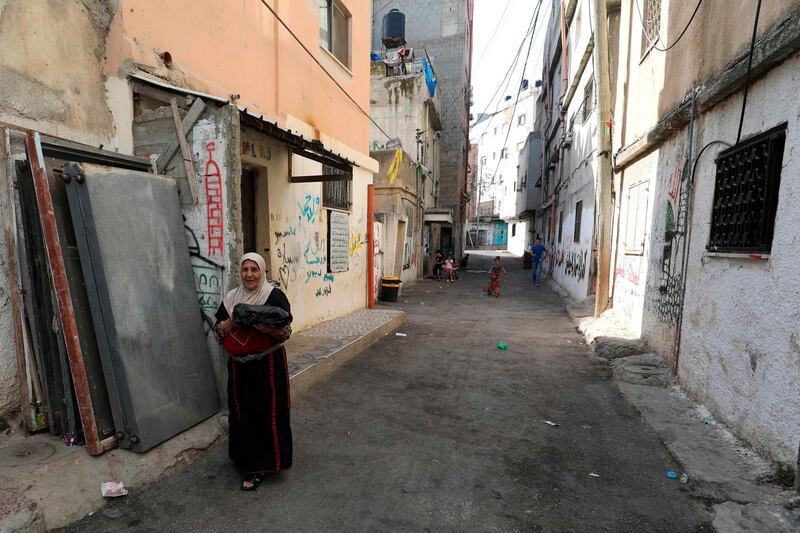 A Palestinian woman walks down a street in the Amari refugee camp near the West Bank city of Ramallah.  AFP