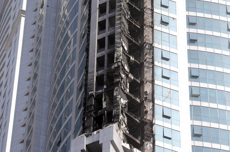 A picture taken on August 4, 2017 shows a close-up view of fire damages to "The Torch", one of the tallest towers in Dubai, after a fire blaze ripped through it early in the morning.
This is the second blaze to hit the skyscraper after a previous inferno in 2015 caused extensive damage to its luxury flats and triggered an evacuation of nearby blocks in the Marina neighbourhood.
Authorities said no casualties were reported from the blaze which erupted in the middle to upper floors of The Torch, once the tallest residential development in the world. / AFP PHOTO / KARIM SAHIB