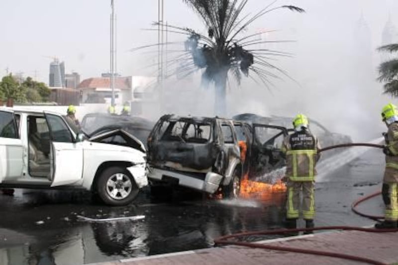 Dubai - August 4, 2010 - Dubai firefighters extinguish this fire resulting from a multi-car accident on Al Soufah Road near Knowlege Village in Dubai, August 4, 2010. (Photo by Jeff Topping/The National) 
 