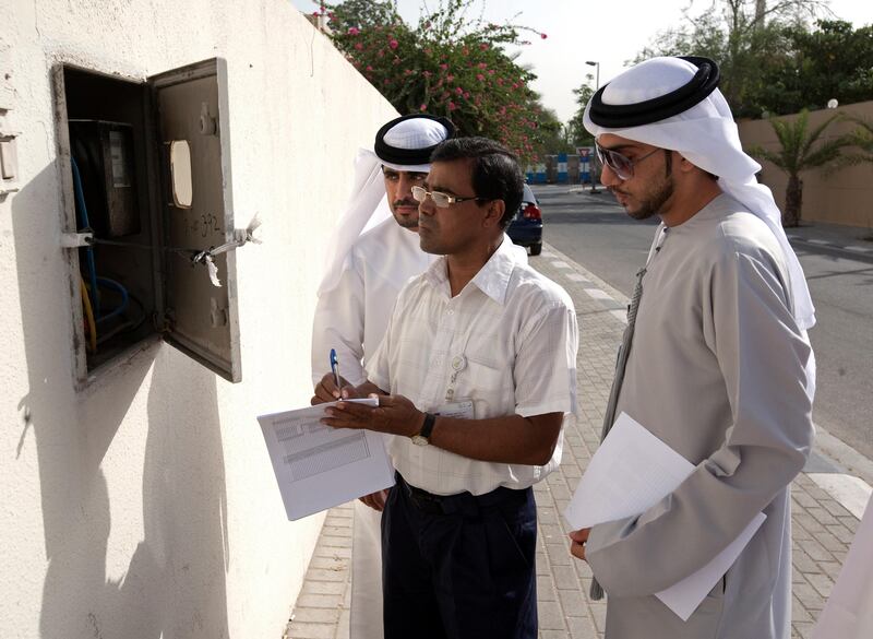 Jafliya - June 24, 2010 - DEWA assistant engineer, Zahid Mahmud (C) with Dubai government employees, checks the meter of a villa that will have its' power cut in Jafliya, Dubai, June 24, 2010. (Photo by Jeff Topping/The National) 
 