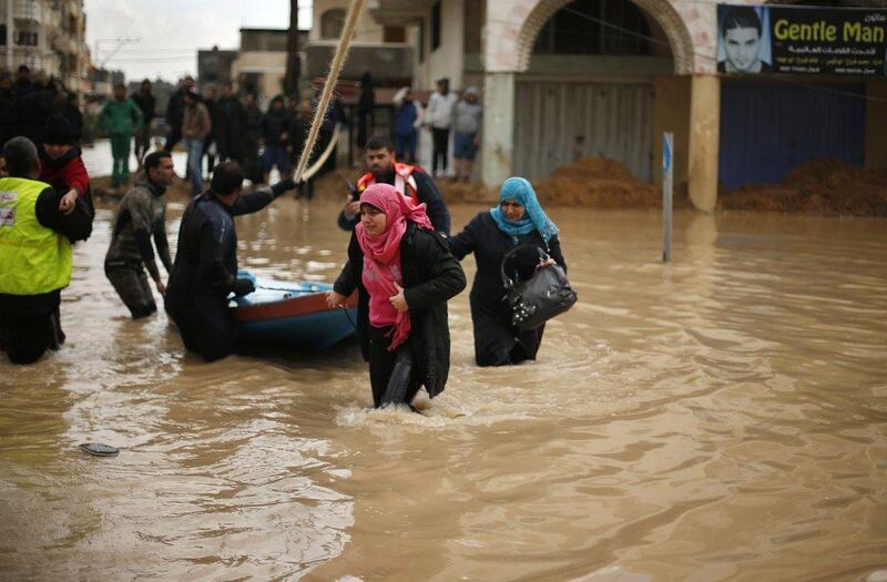 Members of the Palestinian civil defence evacuate people from their homes. Mohammed Salem / Reuters