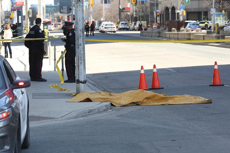 Police officers stand near a victim of the attack. It is not know yet wat the attacker's motives were. AFP/Lars Hagberg