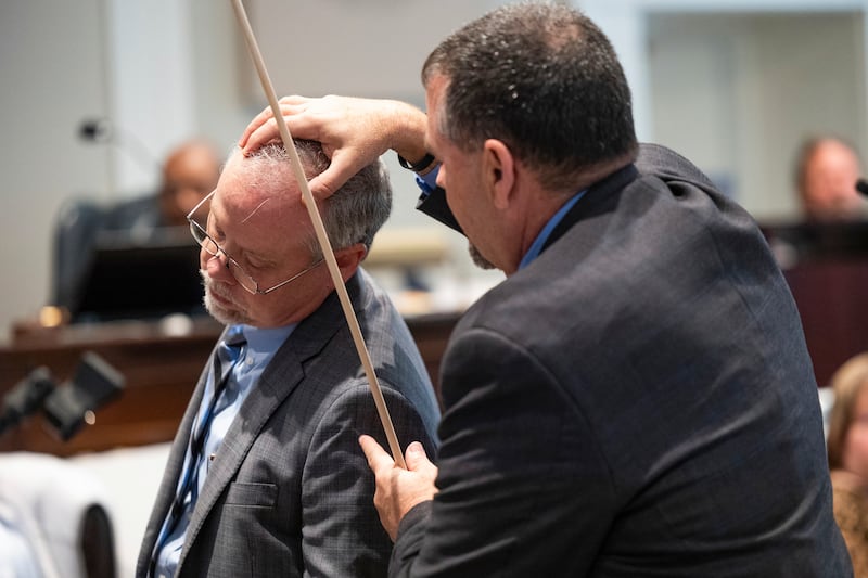 Crime scene specialist Kenneth Kinsey, right, shows where he believes a shotgun round entered Paul Murdaugh's skull.  AP