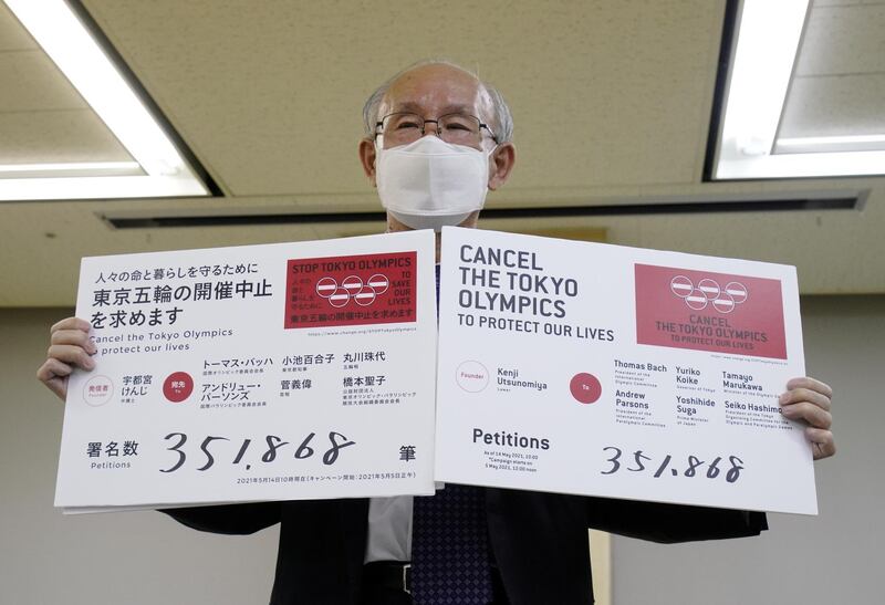 Lawyer Kenji Utsunomiya shows off placards during a news conference after he and anti-Olympics petition organizer to submit a petition calling for the Tokyo 2020 Olympics to be cancelled to Tokyo Governor Yuriko Koike (not in picture) at the Tokyo Metropolitan Office press club in Tokyo, Japan May 14, 2021.  REUTERS/Naoki Ogura
