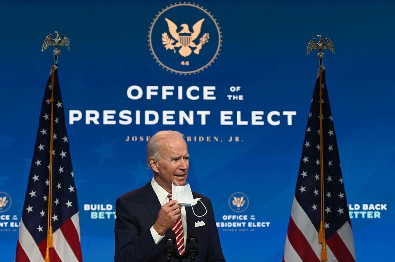 US President-elect Joe Biden shows a face mask as he answers questions about COVID 19 from the press at The Queen in Wilmington, Delaware on November 16, 2020.  US President-elect Joe Biden expressed frustration on November 16, 2020 about Donald Trump's refusal so far to cooperate on the White House transition process, saying "more people may die" without immediate coordination on fighting the coronavirus pandemic. / AFP / ROBERTO SCHMIDT
