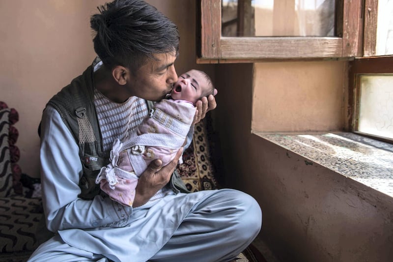 Agha Gul, a 35-year-old father holds his newborn daughter Zahra. Now I am both your father and your mother," he told her. 
