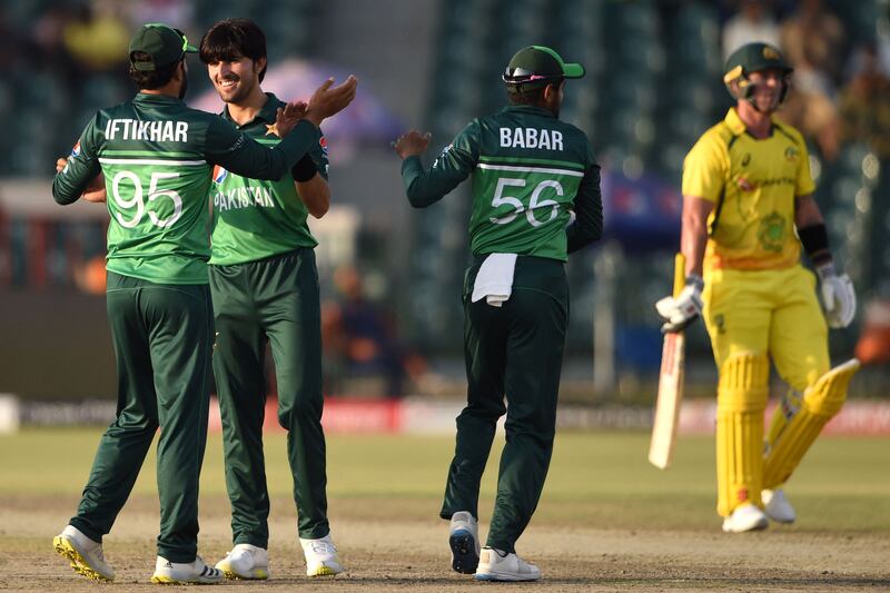 Pakistan's Mohammad Wasim celebrates with teammate Iftikhar Ahmed and captain Babar Azam after taking the wicket of Australia's Ben McDermott. AFP