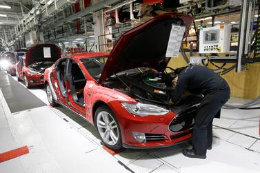 Tesla employees work on a Model S cars in the Tesla factory in Fremont, California. Tesla chief executive is threatening to pull the company's factory and headquarters out of the state. AP Photo