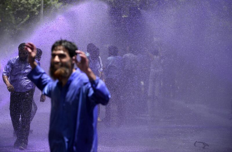 Kashmiri government teachers shout anti government slogans as Indian police spray purple coloured water during a protest in Srinagar. Tauseef Mustafa/AFP