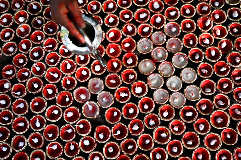 A potter pours wax into earthen lamps used for Diwali in New Delhi. AFP