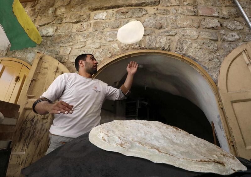 A Palestinian man bakes traditional bread in the occupied West Bank city of Hebron. AFP