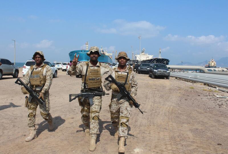 Soldiers loyal to Saudi-led coalition forces gesture as they guard ships docked in the southern Yemeni port of Aden. Saudi ambassador to Yemen arrives in the southern Yemeni port of Aden to oversee an aid delivery of fuel from Saudi Arabia.