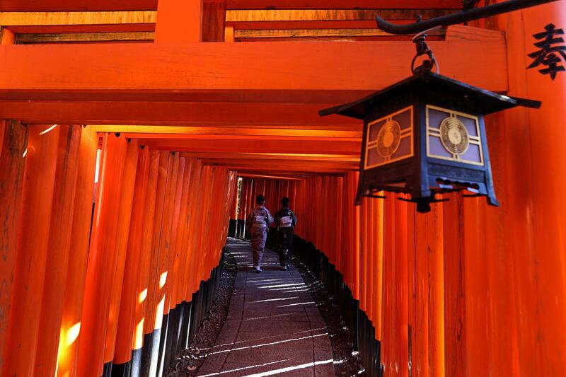 Women dressed in kimonos walk through the deserted torii path Fushimi Inari Taish shrine in Kyoto, Japan. Getty Images