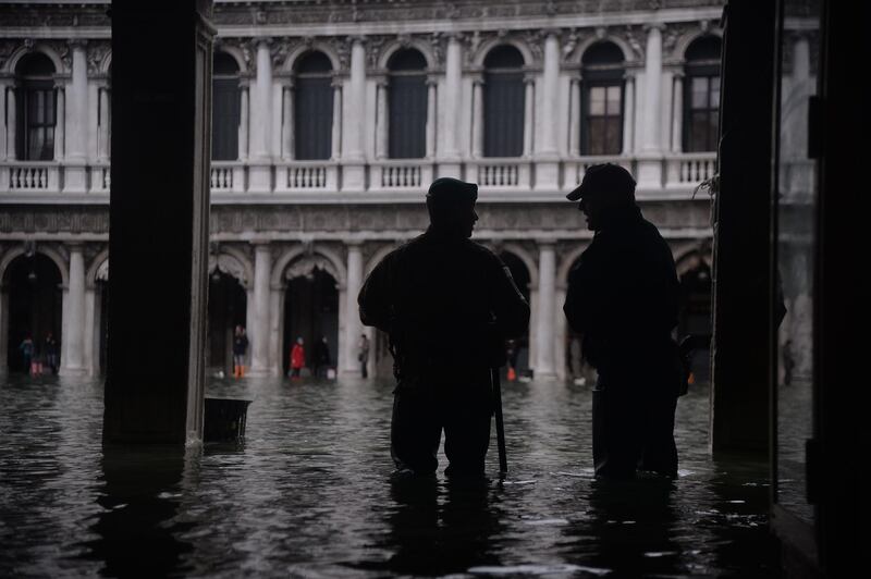 Persons stand in floods in Venice, in the morning of November 17. Filippo Monteforte / AFP