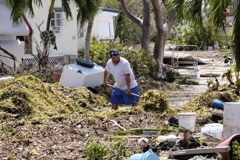 (FILES) This file photo taken on September 12, 2017 shows Iliat Martin shoveling seagrass from the entrance of his mobile home in the wake of hurricane Irma at Tavenier Key, Florida.
US payrolls contracted in September for the first time in seven years as major hurricanes left workers idled in southern states but unemployment continued to fall, official data showed on October 6, 2017. Total non-farm employment fell by 33,000 net positions for the month, with a steep drop-off in hiring at restaurants and bars, according to the Labor Department. But the unemployment rate fell another two tenths to 4.2 percent, its lowest level since February of 2001.  / AFP PHOTO / Gaston De Cardenas