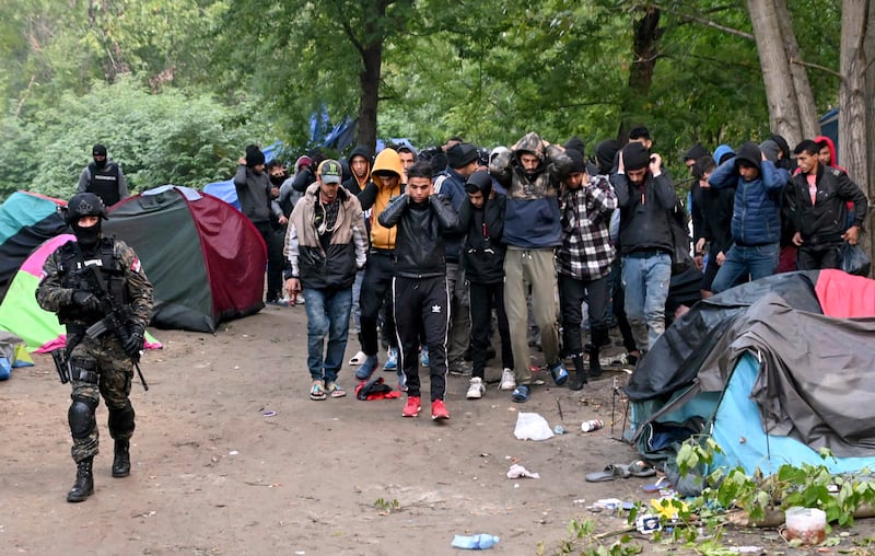 Migrants are escorted by Serbian police near the border with EU member Hungary. AP