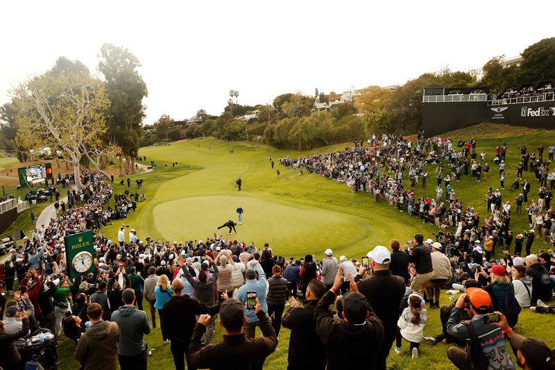 Crowds watch Tiger Woods on the 18th green during the first round of the the Genesis Invitational. Getty